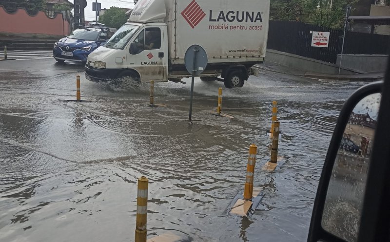 Ploaia a făcut, din nou, ravagii la Cluj! Sens giratoriu, înecat sub ape. Noroc cu stâlpișorii...