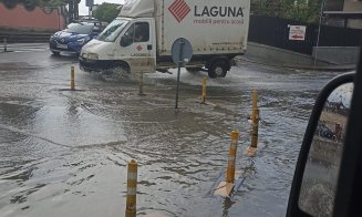 Ploaia a făcut, din nou, ravagii la Cluj! Sens giratoriu, înecat sub ape. Noroc cu stâlpișorii...
