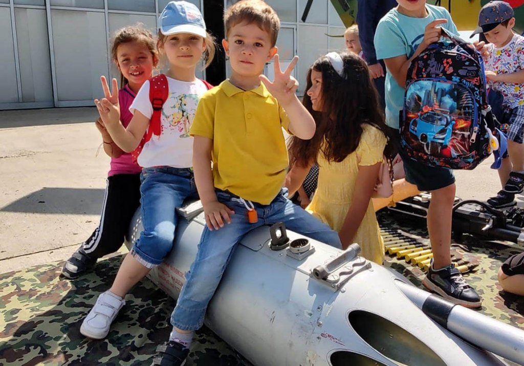 Copii de grădiniță, călare pe rachete și cu pușca în mână, la baza aeriană de la Câmpia Turzii