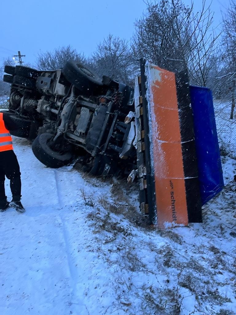 Utilaj de deszăpezire din Cluj, cu roţile în sus, în şanţ