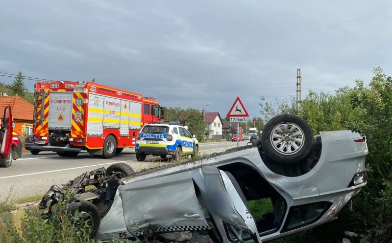 Taxi RĂSTURNAT pe un drum din Cluj. Mașina s-a făcut zob/ Un bărbat a fost transportat la spital